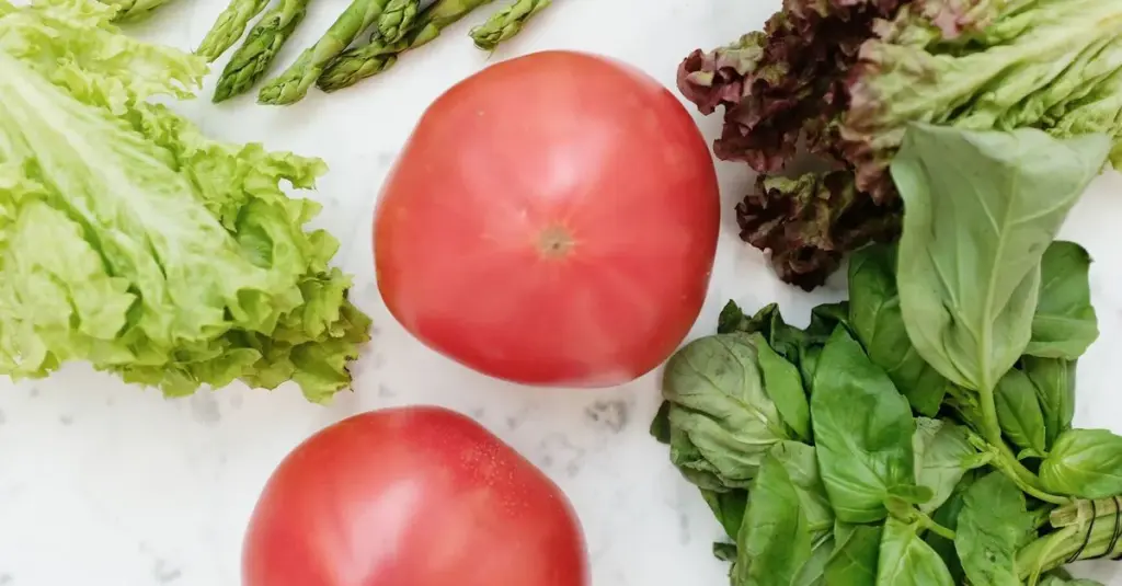 Fresh prostate-healthy foods including tomatoes, leafy greens and asparagus